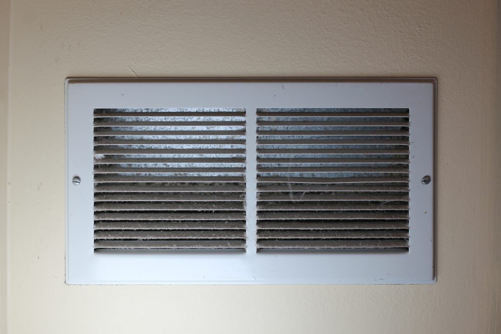 close-up of dusty air register ventilation system dirty needs cleaning abstract background